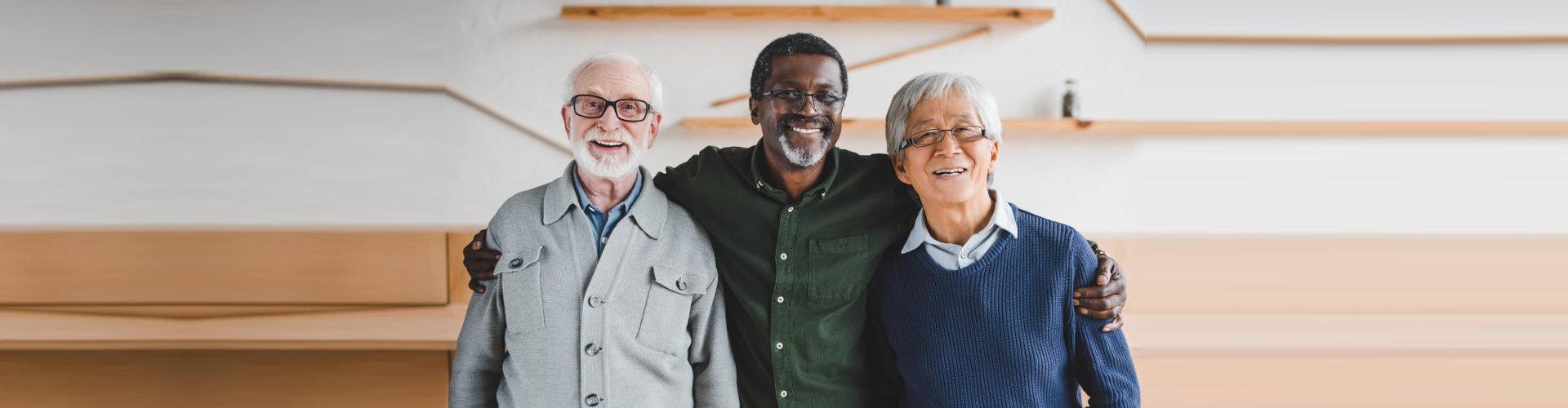 three elderly men smiling